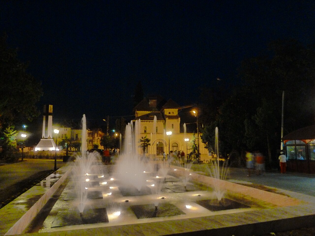 Fântâna luminată de la intrarea în Parcul Băilor, într-o seară de vară. Imagine redimensionată; încadrare adaptată pentru afișare.